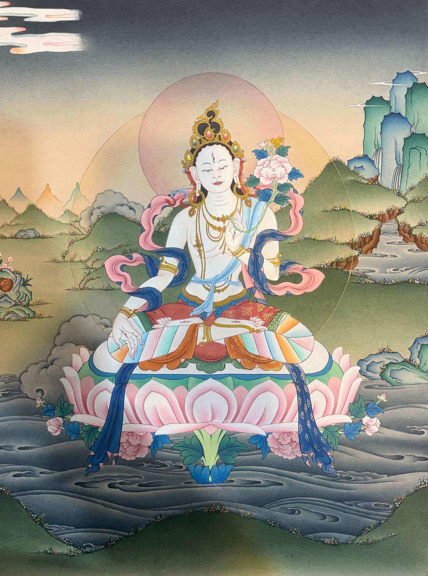 White Tara thangka painting: seated white goddess on lotus, blue robes, floral details.