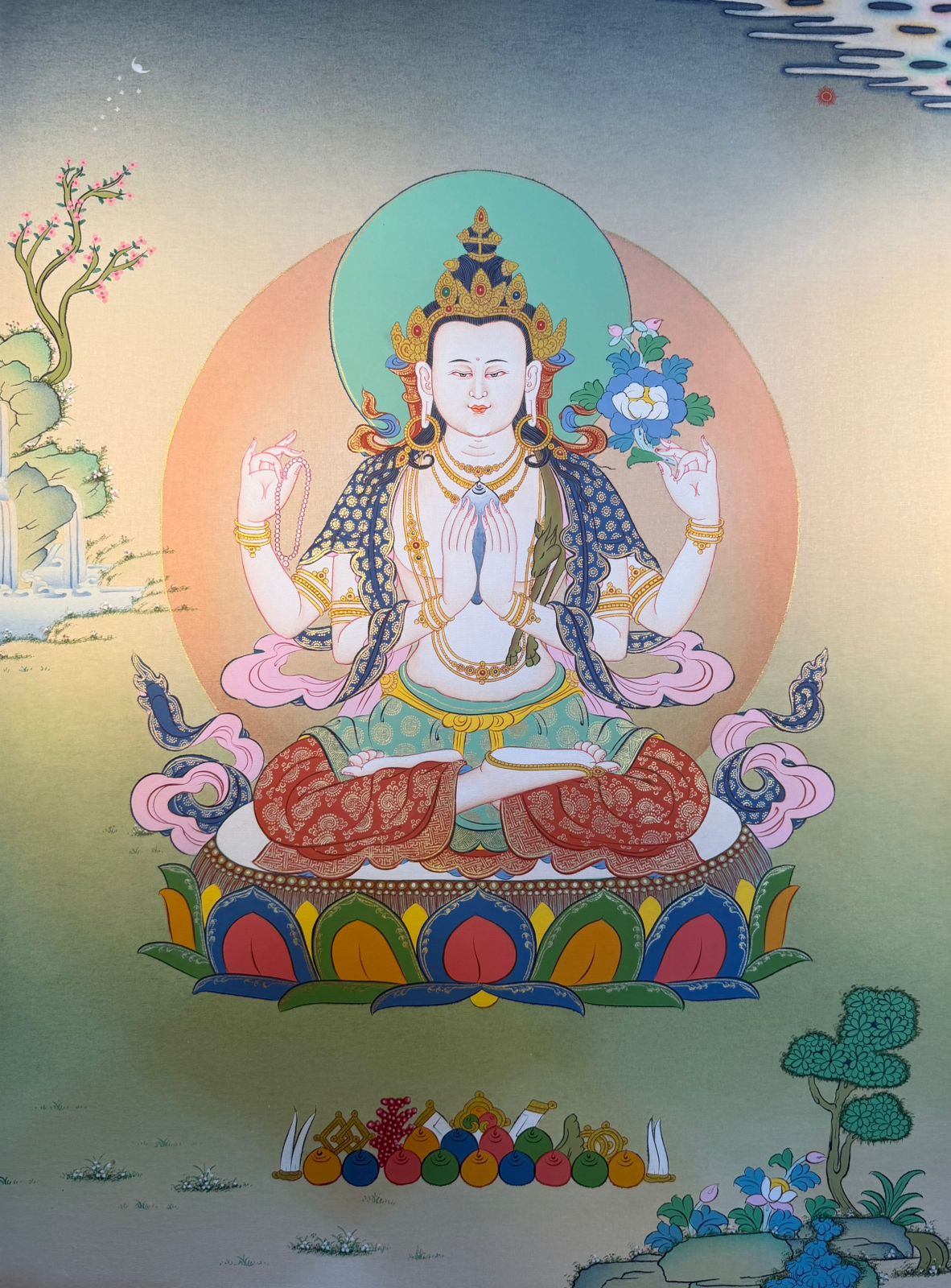 Thangka painting of a seated deity with blue halo, lotus seat, and offerings at bottom