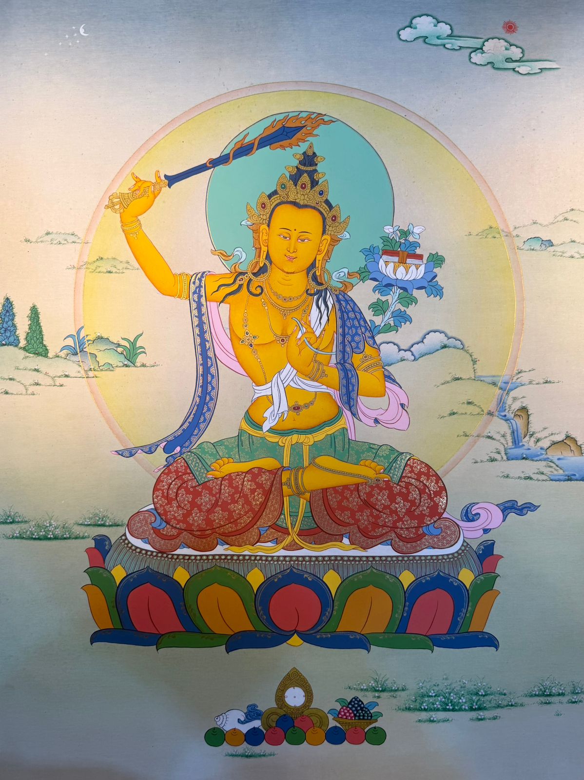 Framed thangka painting of seated deity with halo, lotus seat, flowing robes and clouds