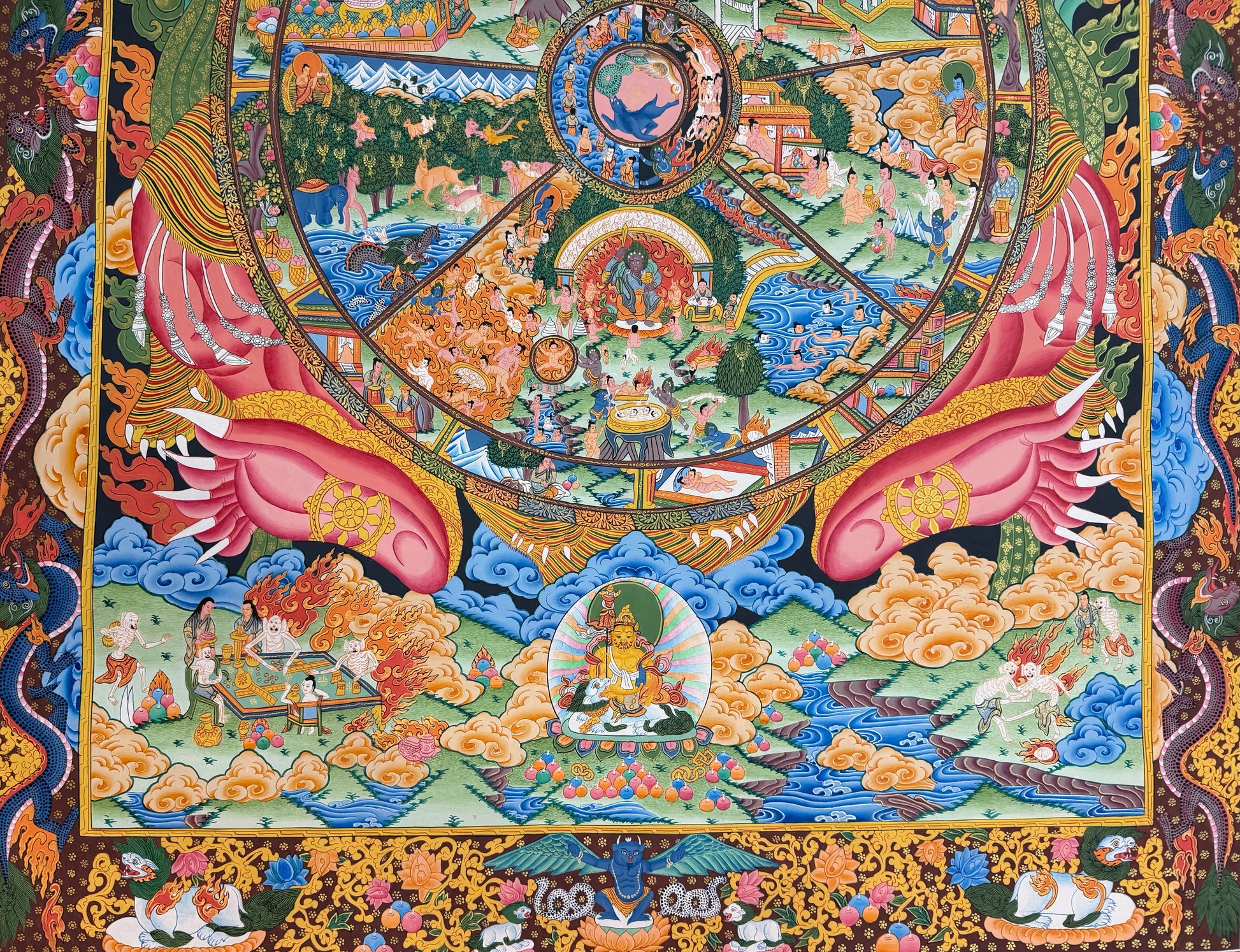 Thangka painting lower section with pink hands, circular wheel details, clouds, and decorative border