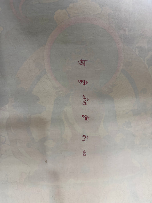 Amitayus Buddha thangka painting with vertical red Tibetan script on light background